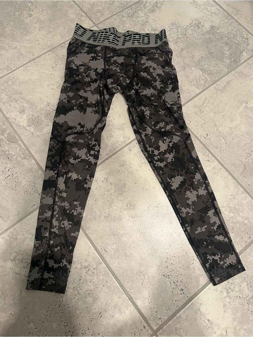 Nike Pro Hypercool compression tights in a grey digital camouflage pattern.